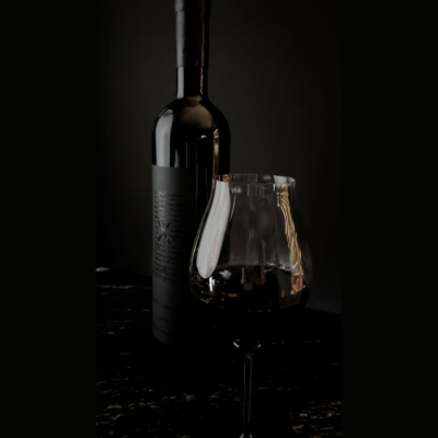 A bottle and glass of red wine, a special collaboration between KOLI and Casa Madero, highlighting elegance and fine dining pairings.