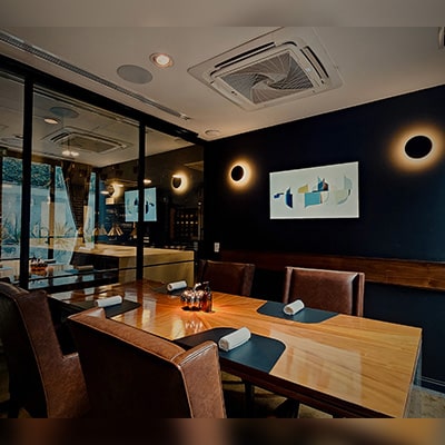 mesadelchef A private dining room at KOLI, featuring an elegant wooden table, warm lighting, and minimalist details that create an intimate atmosphere perfect for personalized dining experiences.